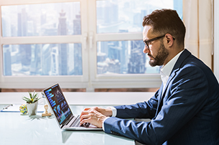 Ein Geschäftsmann, der an seinem Laptop arbeitet